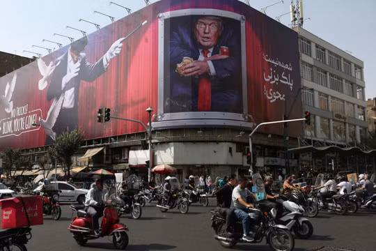 Người dân lái xe gần một bảng quảng cáo có hình Tổng thống Mỹ Donald Trump trên một tòa nhà ở Tehran, Iran, ngày 31/8. Ảnh: Reuters.