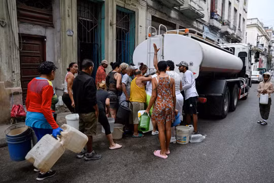 Người dân tập trung quanh một xe bồn chở nước để múc nước vào xô và các vật chứa khác do tình trạng thiếu nhiên liệu nghiêm trọng đã làm gián đoạn việc bơm và phân phối nước, tại Havana, Cuba ngày 19/3. Ảnh: Reuters.