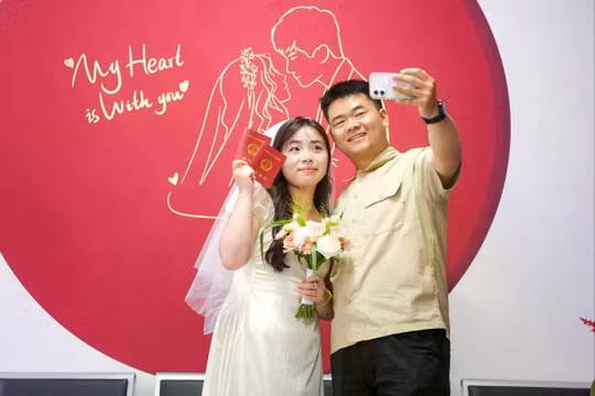 Một cặp vợ chồng mới cưới chụp ảnh selfie với giấy chứng nhận kết hôn tại văn phòng đăng ký kết hôn ở tỉnh Hà Nam, miền Bắc Trung Quốc. Ảnh: Getty.