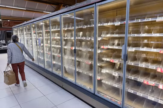 Một người đi ngang qua những chiếc tủ lạnh trống rỗng tại siêu thị Intermarché ở Névez, Pháp hôm 12/10. Ảnh: AFP.
