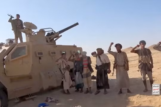 Các chiến binh Houthi đứng cạnh một chiếc xe quân sự bị thu giữ ở Yemen. Ảnh: Reuters.
