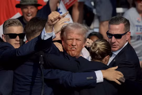 Ông Donald Trump được lực lượng Mật vụ hỗ trợ sau khi tiếng súng vang lên trong một cuộc mít tinh tranh cử tại Hội chợ Nông nghiệp Butler ở Butler, Pennsylvania, Mỹ, ngày 13/7/2024. Ảnh: Reuters.