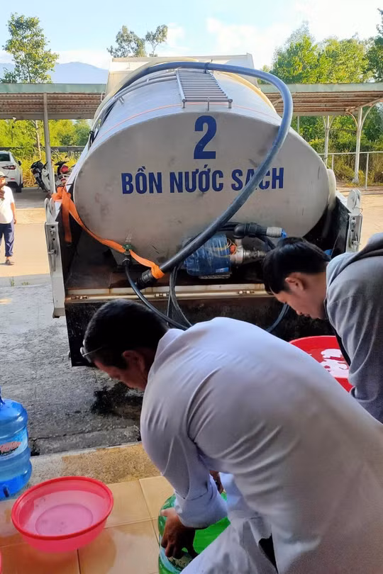 Nhân viên y tế Cơ sở Chân Mây - Trung Tâm y tế Phú Lộc hứng nước sinh hoạt từ xe bồn tiếp nước của HueWaco sau khi cơ sở mất nước hoàn toàn chiều 26/8. Ảnh: NL.