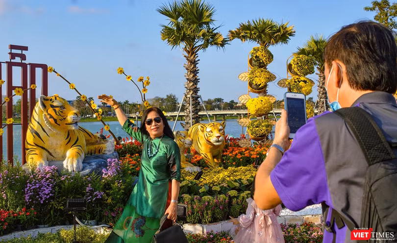 Người dân TP Huế chụp ảnh kỷ niệm với đường hoa xuân Nhâm Dần bên bờ sông Hương (ảnh Tuấn Hiệp)