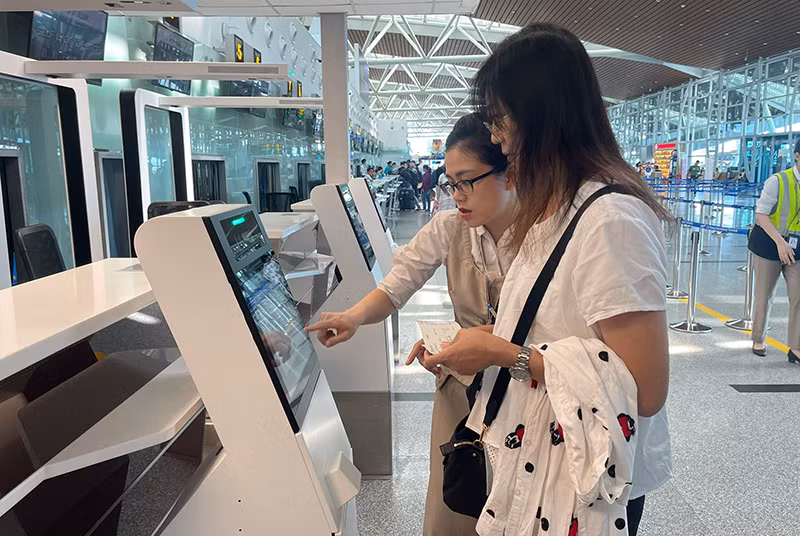 Nhân viên hướng dẫn hành khách sử dụng dịch vụ ký gửi hành lý tự động thông qua việc tích hợp hệ thống quầy tự gửi hành lý (self-bag drop) tại Nhà ga T2 Đà Nẵng