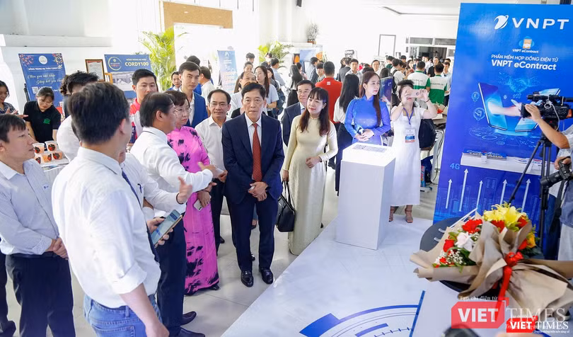 Thứ trưởng Bộ KH&amp;CN Trần Văn Tùng (mặc comple, đứng giữa) và bà Ngô Thị Kim Yến - Phó Chủ tịch UBND TP Đà Nẵng (áo dài hồng) cùng các đại biểu tham quan gian hàng triển lãm tại SURF Da Nang 2022