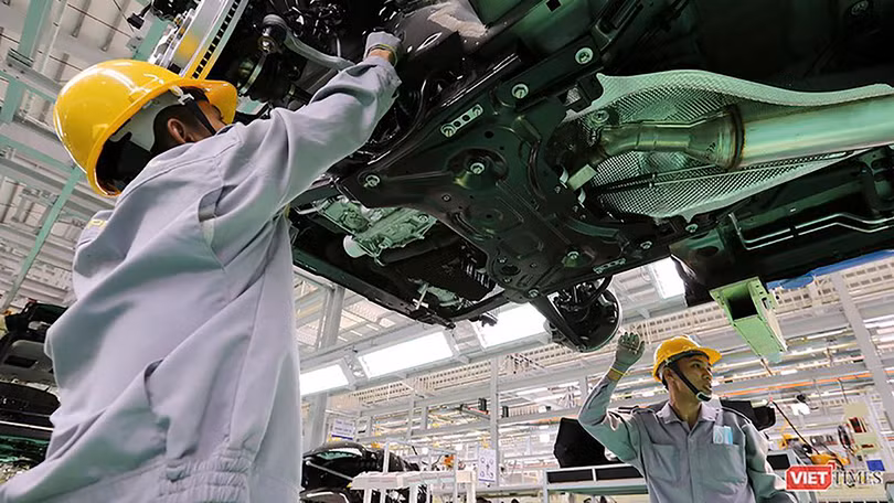 Công nhân làm việc trong phân xưởng lắp ráp ô tô.
