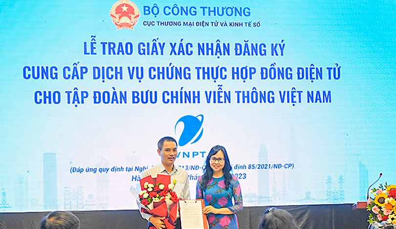Bà Lê Hoàng Oanh – Cục trưởng Cục thương mại điện tử và Kinh tế số - trao giấy xác nhận đăng ký cung cấp dịch vụ chứng thực hợp đồng điện tử cho đại diện VNPT (ảnh VNPT)