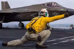 Một thủy thủ Mỹ phóng máy bay F-35C Lightning II, thuộc Phi đội tấn công chiến đấu Thủy quân lục chiến 314, từ boong tàu sân bay lớp Nimitz USS Abraham Lincoln trong cuộc xung đột đang diễn ra với Iran, ngày 5/8. Ảnh: Reuters.