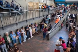 Người dân Venezuela xếp hàng chờ mua hàng hóa thiết yếu bên ngoài một siêu thị ở thủ đô Caracas.