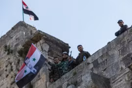 Cờ Syria được các binh sĩ gương cao trên tòa nhà mới chiếm lại