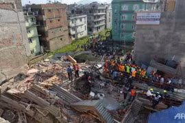 Tìm kiếm và cứu hộ nạn nhân ở một tòa nhà đổ sập tại Kathmandu sau trận động đất mạnh 7,3 độ richter ngày 12-5 Ảnh: AFP