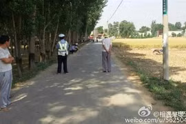 Cảnh sát và người dân tại làng Xishibao, tỉnh Hà Bắc, nơi xảy ra vụ xả súng. Ảnh: Weibo