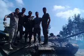 Binh sĩ lực lượng vũ trang địa phương NDF trên xe tăng quân đội Syria