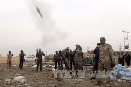 Các lực lượng dân quân người Shiite giao tranh với phiến quân IS tại trung tâm thành phố Tikrit ngày 12/3. Ảnh: AFP/TTXVN.