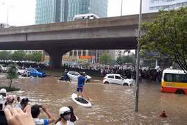 Người dân chèo thuyền trên đường vành đai 3 trong trận mưa ngày 25/5/2016