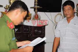 Công an đọc lệnh bắt tạm giam ông Bùi Văn Minh - Ảnh: Phan Tại/Tuổi trẻ