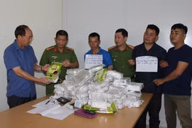 Các đối tượng Lả, Linh (cầm giấy) cùng tang vật bị bắt giữ tại cơ quan công an.