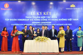 Ông Dương Trí Thành - TGĐ Vietnam Airlines và ông Nguyễn Việt Quang, Phó Chủ tịch kiêm TGĐ Tập đoàn Vingroup ký kết và trao đổi thỏa thuận hợp tác dưới sự chứng kiến của các đại diện lãnh đạo hai bên. (Ảnh: VNA)