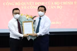 Ông Lê Quốc Minh nhận quyết định và hoa chúc mừng từ ông Nguyễn Trọng Nghĩa.