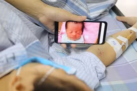 Chị Vang ngắn nhìn đứa con thơ trong lúc điều trị ung thư máu.