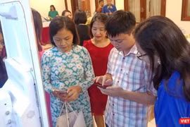 Các chuyên gia y tế trải nghiệm phương thức thanh toán viện phí, hóa đơn dịch vụ không dùng tiền mặt bên lề hội nghị do Bộ Y tế tổ chức sáng 20/9.