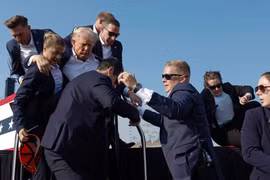 Cựu Tổng thống Donald Trump được các nhân viên Sở Mật vụ bảo vệ ra khỏi sân khấu (Ảnh: Getty)
