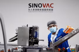 Một nhân viên làm việc trên dây chuyền sản xuất của Sinovac (Ảnh: Nikkei)
