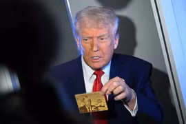 Tổng thống Mỹ Donald Trump cầm Thẻ vàng trị giá 5 triệu USD khi phát biểu với các phóng viên trên chuyên cơ Không lực Một, trên đường đến Miami vào ngày 3/4. Ảnh: AFP.