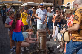 Du khách ở Rome bao quanh một vòi nước công cộng giữa tiết trời nắng nóng (Ảnh: Bloomberg)