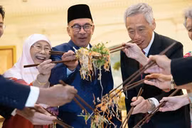 Các chính trị gia, bao gồm Thủ tướng đương nhiệm Singapore Lawrence Wong (trái) và Thủ tướng Malaysia Anwar Ibrahim (thứ ba từ trái sang), trộn một đĩa Yusheng trong lễ đón Tết Nguyên đán năm 2023. Ảnh: AFP.
