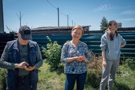 Vadym Smirnov, Alla Voloshynovych cô con gái Anastasia Smirnov đứng trên mảnh vườn đã được dọn gần hết mảnh đạn (Ảnh: Al Jazeera)