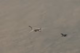 Máy bay ném bom Tu-160 của Nga được hộ tống bởi một chiếc Su-30SM (Ảnh: RT)