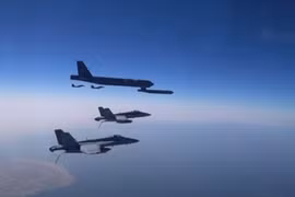 Máy bay ném bom B-52 Stratofortress của Mỹ được hộ tống bởi các chiến đấu cơ (Ảnh: RT)