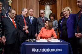 Chủ tịch Hạ viện Nancy Pelosi ký 2 điều khoản luận tội Trump để chuyển cho Thượng viện (Ảnh: Guardian)
