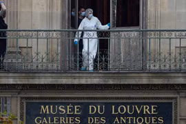 Một nhân viên pháp y người Pháp đang kiểm tra cửa sổ và ban công của Bảo tàng Louvre ở Paris vào ngày 19/10. Ảnh: Getty.