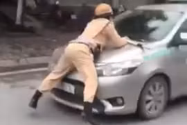 Hình ảnh Trung úy CSGT bị hất tung lên nắp capô taxi vào chiều nay. Ảnh chụp màn hình video: Anh Lê