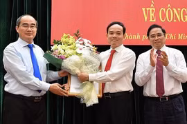 Bí thư Thành ủy TP.HCM Nguyễn Thiện Nhân (ngoài cùng, bên trái) tặng hoa chúc mừng tân Phó Bí thư Thường trực Thành ủy TPHCM Trần Lưu Quang (ở giữa) - Ảnh: SGGP