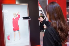 Nhân viên JD.com giới thiệu hệ thống AR cho phép khách hàng thử đồ ảo tại shop. Ảnh: AFP.