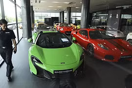 Một viên cảnh sát kiểm tra tại showroom kinh doanh siêu xe đã qua sử dụng bị nghi ngờ buôn lậu ở Thái Lan. Ảnh: Bangkok Post