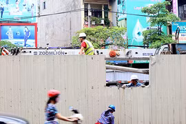 Vết rách ở tường rào do thanh cừ đổ vào sáng nay đang được công nhân bịt lại, chiếc cần cẩu trong công trường cũng được hạ xuống.