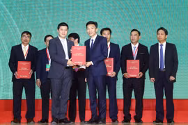 Ông Trần Nhật Nam - P.TGĐ SHB (bên trái) trao thỏa thuận tài trợ tín dụng với hạn mức 770 tỷ đồng cho ông Nguyễn Chánh Trung – Chủ tịch kiêm CEO CTCP Gạo Hạnh Phúc để triển khai đầu tư xây dựng nhà máy chế biến gạo tại xã Lương An Trà, Tri Tôn, An Giang.