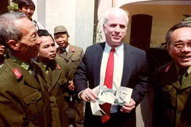 2-	Thượng nghị sỹ John McCain cầm những tấm hình đen trắng chụp ông khi bị bắt làm tù binh ở Hà Nội năm 1967 trong một chuyến đến thăm Bảo tàng quân đội nhân dân Việt Nam ngày 9/10/1992.Ảnh: Hoàng Đình Nam/ AFP.