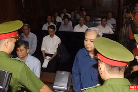 Các bị cáo Nguyễn Hữu Tín và Đào Anh Kiệt trong vòng vây của cảnh sát bảo vệ tại tòa. Ảnh: GVT.