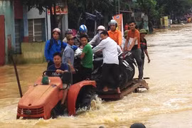 Tại Thanh Hóa, người dân dùng xe công nông để vận chuyển người và phương tiện qua đoạn ngập. Ảnh: L.H/ VnE