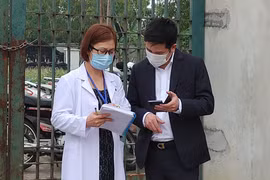 Nhân viên y tế làm việc bên ngoài cổng Trường Tiểu học Xuân Phương vào chiều qua (1/2) (Ảnh - Khánh Linh) 