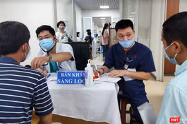 Bác sĩ khám sàng lọc cho người dân trước khi tiêm vaccine phòng COVID-19 (Ảnh - Minh Thuý) 