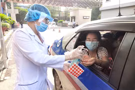 Nhân viên y tế hỗ trợ rửa tay cho người dân trước khi vào bệnh viện (Ảnh - Minh Thuý) 