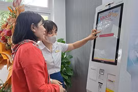 Nhân viên Bệnh viện Đà Nẵng hướng dẫn người bệnh sử dụng Ki-ốt y tế thông minh