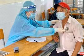 Khám sàng lọc trước khi tiêm chủng COVID-19 cho người dân - Ảnh: HCDC